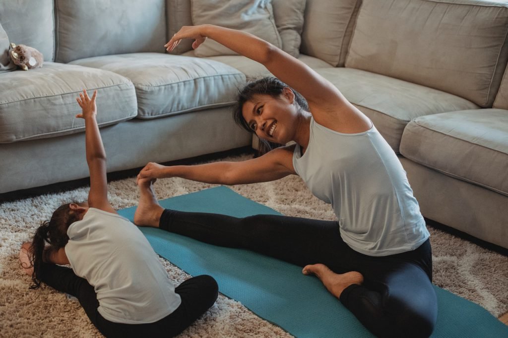 daughter & mom practicing yoga at home