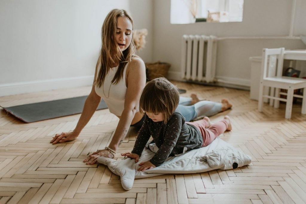 Child practicing yoga with mom